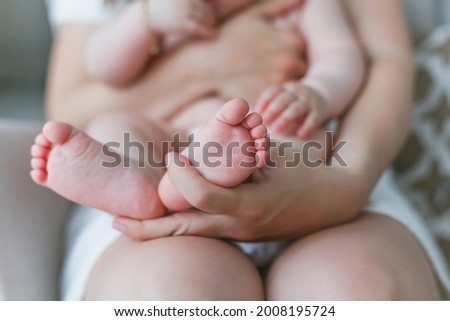 Close-up of baby's feet in mom's. Baby. Home.