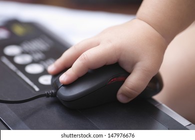 Closeup of baby's hand using computer mouse