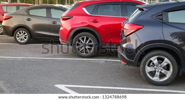 Closeup of back or rear\
side of black car and other cars parking in parking area with\
natural background in twilight evening. The mean of transportation\
in modern world.