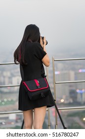 Closeup Back View Of Female Photographer Taking Photo Of Aerial Cityscape From Top Of High Building. Concept Of Woman, Female Photographer