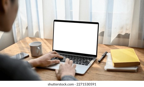 Close-up back view image of an Asian male freelancer or office worker remote working at the cafe co-working space, using his laptop. laptop white screen mockup - Powered by Shutterstock