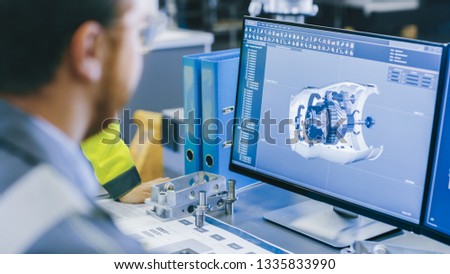 Close-up Back View of the Mechanical Engineer Designing 3D Engine Model on Personal Computer. Professional Working At the Factory.