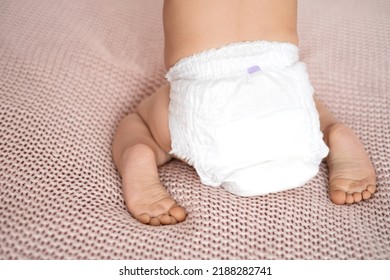 Close-up From The Back. A White Diaper On A Baby. The Legs Of The Child. Mockup. Space For Text