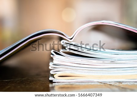 Closeup background of a pile of old magazines with bending pages