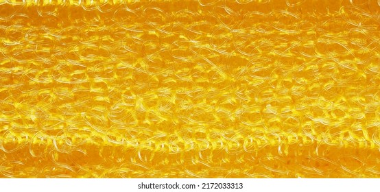 closeup, background, texture, large long horizontal banner. heterogeneous surface structure bright saturated yellow sponge for washing dishes, kitchen, bath. full depth of field. high resolution photo - Shutterstock ID 2172033313