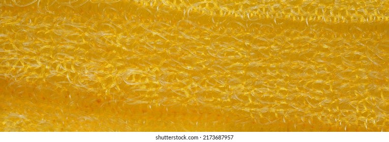 closeup, background, texture, large long horizontal banner. heterogeneous surface structure bright saturated yellow sponge for washing dishes, kitchen, bath. full depth of field. high resolution photo - Shutterstock ID 2173687957