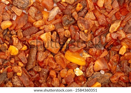 Close-up. Background, texture. Orange, brown and yellow natural, raw amber stones found on the Polish cost of the Baltic Sea 

