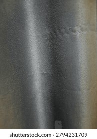 Close-up background texture of smooth black satin fabric with a subtle metallic sheen and soft vertical light reflection.