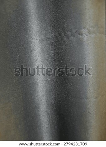 Close-up background texture of smooth black satin fabric with a subtle metallic sheen and soft vertical light reflection.