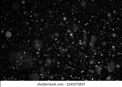 closeup background texture of snowflakes during a snowfall on a black background