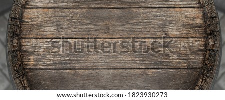 Close-up background of top of old retro vintage weathered wooden cask barrel. Wineyard, distillery, pub or bar table decoration design. Copyspace abstract natural flat lay surface. Panoramic banner