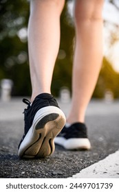 close-up backside view Athlete runner feet running or walking on the road