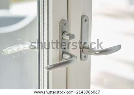 Close-up of balcony doors with two silver handles and double glazed windows