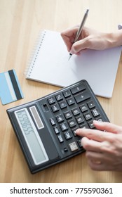 Closeup Of Banker Using Calculator And Writing