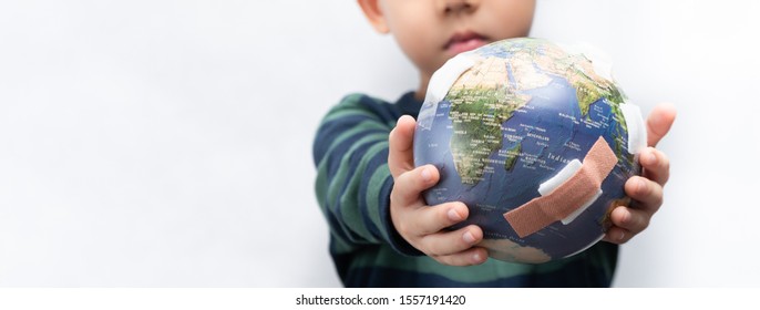 Closeup banner of a cute little asian boy a new generation presenting a damage globe full of bandages. Global warming, Climate change, Environmental problems. World pollution, Earth day, Net zero.