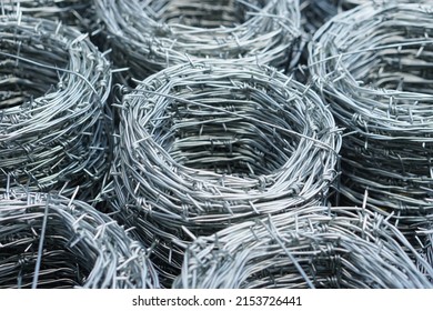 Closeup barbed wire rolled in circle background. Barbed wire is used for make fences , secure property and make border to show the territory of  area.                               