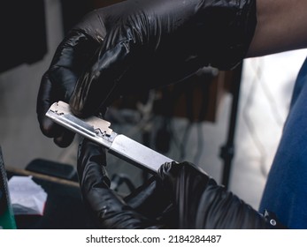 Closeup Of A Barber Loading A Stainless Steel Blade Into A Shavette Or Straight Razor. Preparing A Shaving Tool At A Barbershop.