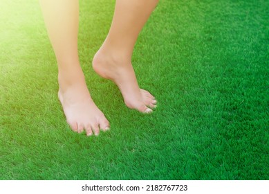 Close-up Of Bare Feet On Green Artificial Turf. Soft, Clean And Antibacterial Artificial Grass Surface