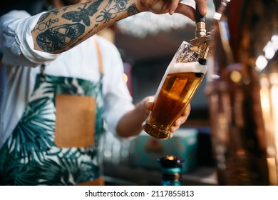 Close-up of barista pouring beer from beer tap while working in a pub.  - Powered by Shutterstock