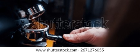 Close-up of a barista using an espresso machine. Warm colors, professional setting. Perfect for coffee-related promotions. Wide banner with copy space.