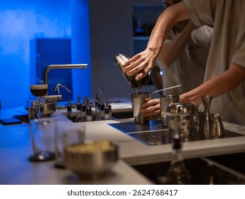 Close-up of bartender preparing a drink with precision and skill, surrounded by cocktail tools and elegant decor.