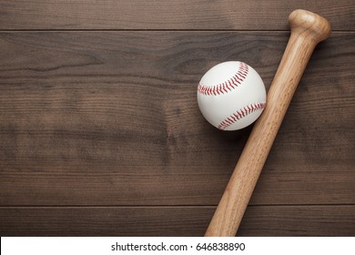 closeup of baseball bat and ball on wooden table with copy space