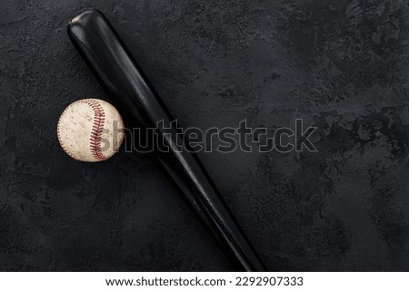 closeup of baseball bat and ball on dark background with copy space