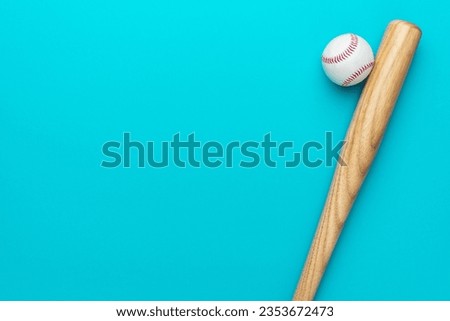 Closeup of baseball bat and ball on turquoise blue background with copy space.