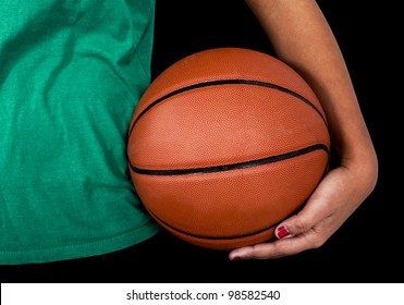 Close-up Of A Basketball With Woman Holding It. Studio Shot With Black Background