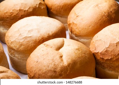 a close-up of a batch of round white bread loafs cooling off on a counter