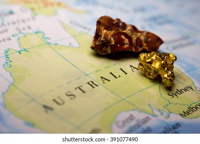 Close-up Of Bauxite Mineral And Gold Nugget On Top Of A Map Of Australia