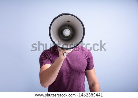 Close-up Of A Beard Man Shouting Through A Megaphone Against Gray Background