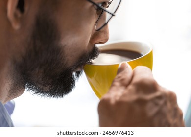 Close-up of a bearded business man drinking coffee in the office, white background - Powered by Shutterstock