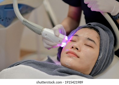 Closeup Of Beautician Using Laser Therapy For Facial Skin Rejuvenation. Beautiful Healthy Woman Face Getting Skin Resurfacing In Spa Salon.