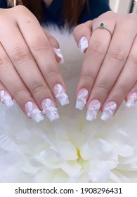 Closeup Of Beautiful 3D Flower See Through Crystal Glass Nail Art Design Manicure Holding A Flower On Soft White Background
