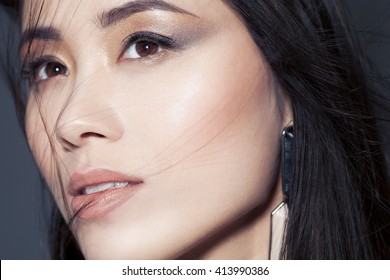 Closeup Of Beautiful Asian Woman With Metallic Smoky Eyeshadow Makeup And Nude Lipstick.