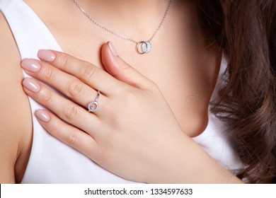 Closeup beautiful brunette girl with long hair in silver jewelry earrings, rings, bracelet, chain, necklace. Сoncept shooting for jewelry store gentle, elegant, delicate, romantic bijouterie on model