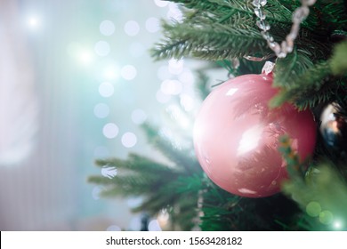 Closeup of beautiful Christmas decorations pink and silver ball hanging on Christmas tree on window background. Christmas winter background. The Concept Of A Happy Christmas.