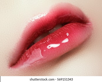 Close-up beautiful female lips with bright lipgloss makeup. Perfect clean skin, light ombre lip make-up. Beautiful spa macro shot with tender pink lip gloss. Spa and cosmetics
