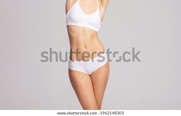 Close-up of a beautiful and fit female\
figure. Studio photo of young woman\'s body in\
swimsuit.