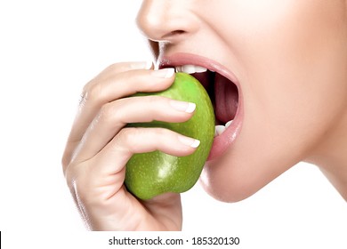 Closeup of beautiful healthy mouth biting a juicy and acid green apple. Closeup portrait isolated on white background