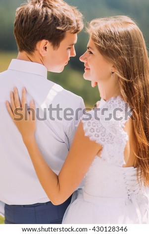 Close-up of beautiful pair holding each other outdoors at sunny day