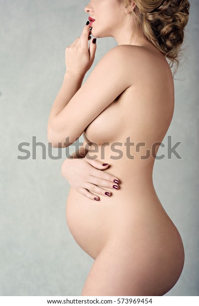 白い背景にエレガントなポーズの美しい妊婦のヌード女性の接写 セクシーなファッションモデルの女の子のポートレート 美しい肉体を持つ官能的な女性 女性の裸の腹の接写 の写真素材 今すぐ編集