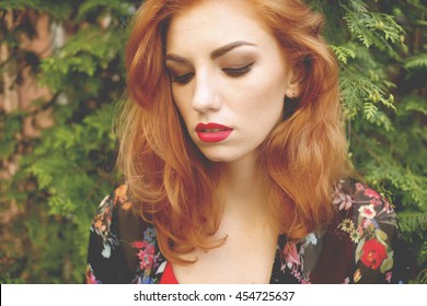 Closeup Of Beautiful Red Haired Woman With Matt Red Lips And Eye Makeup, Eyeliner. Photo Toned Style Instagram Filters