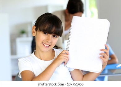 Closeup of beautiful school girl showing notebook page