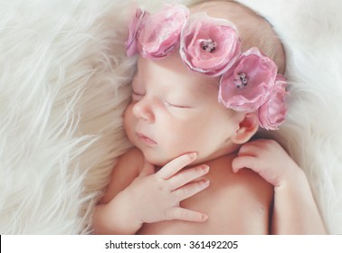 Close-up Beautiful Sleeping Baby Girl. Newborn Baby Girl, Asleep On A Blanket. A Portrait Of A Beautiful, Seven Day Old, Newborn Baby Girl Wearing A Large, Fabric Rose Headband. Closeup Photo