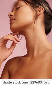 Close-up of a beautiful woman with clean and clear skin. Asian female model with hand on chin and eyes closed.