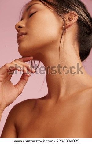 Close-up of a beautiful woman with clean and clear skin. Asian female model with hand on chin and eyes closed.