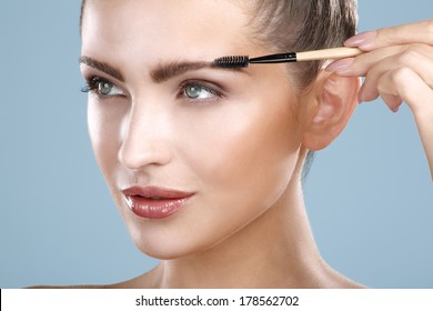 Closeup Beautiful Woman With Eyebrow Brush Tool On Blue