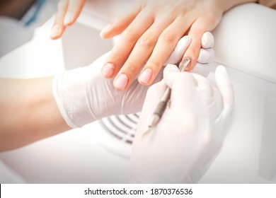 Closeup Of Beautiful Woman's Fingernails Receiving Cleaning Cuticle With Manicure Pusher Tool While Getting A Manicure